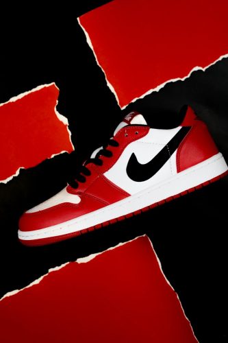 Stylish red and white Nike shoe against a bold abstract background.